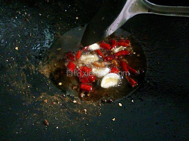 锅中留底油下干辣椒，花椒和蒜，小火炒香。