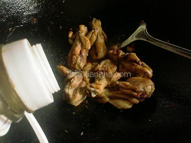 倒入煎好的鸡腿翻炒均匀，淋入1勺料酒继续翻炒。