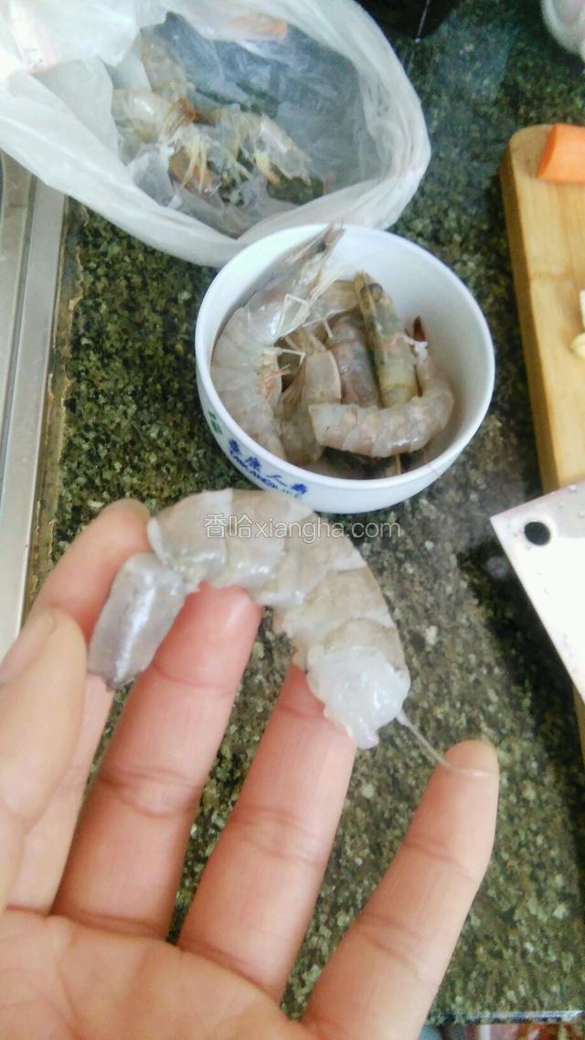 大虾去皮，尾部用刀切开，抽出沙线，如图所示。