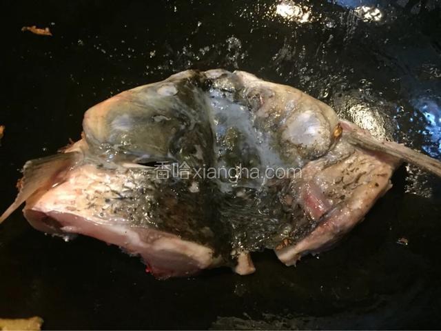 热锅冷油，油热加入拍扁的姜炒香
煎制鱼头两面金黄
