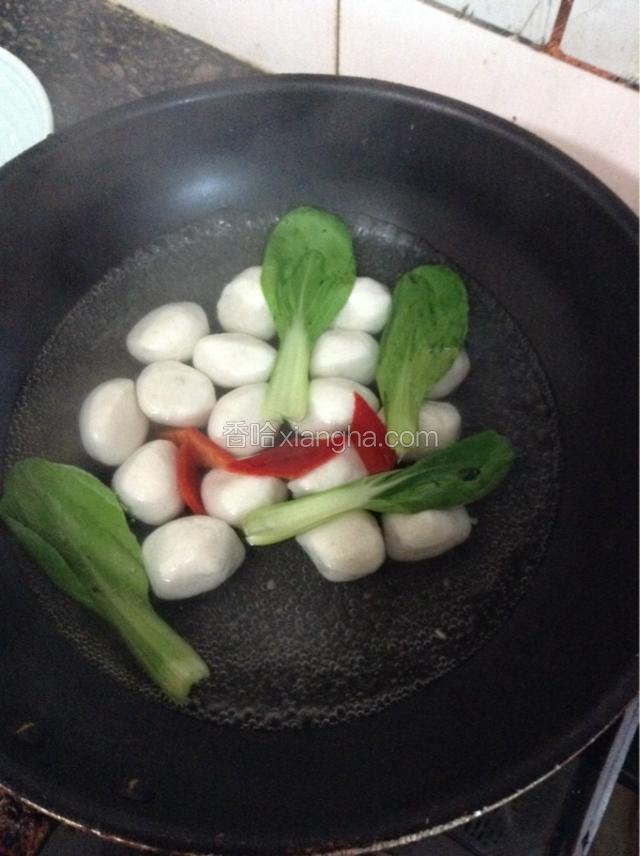 另取一锅加入清水烧开，水开后加入鱼丸青菜和红椒片，水再次开后加少许盐和鸡精调味即可出锅。