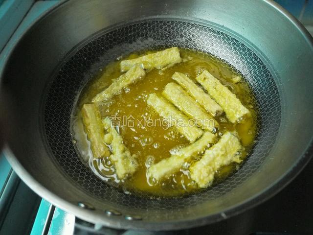 油热后下入茄条，炸至金黄色捞出控油。