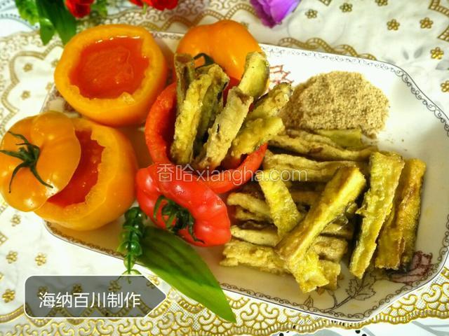 将熬好的西红柿酱加入两个黄色西红柿碗中，炸好的茄条摆在红西红柿碗中、盘中，芝麻盐放在盘边即。