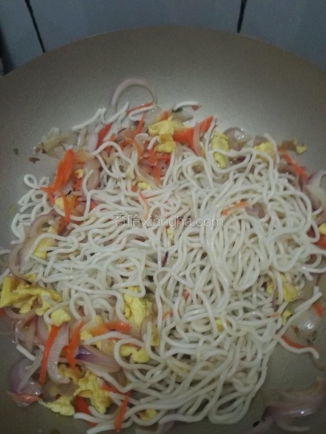 将面条和鸡蛋倒入锅中一同翻炒。