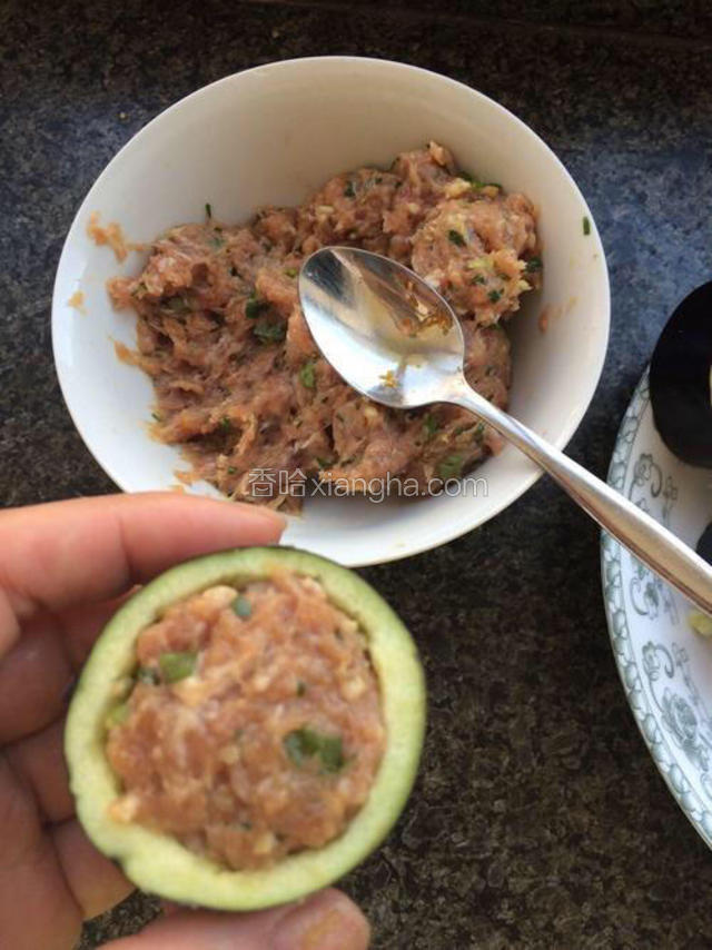 把调好的肉馅用勺子装到茄子段里抹平