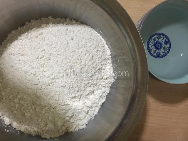将普通面粉倒入盆中，加入适量清水搅匀。
