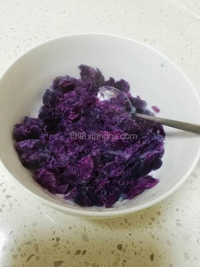 将煮熟的紫薯捞入碗中，用勺子弄碎