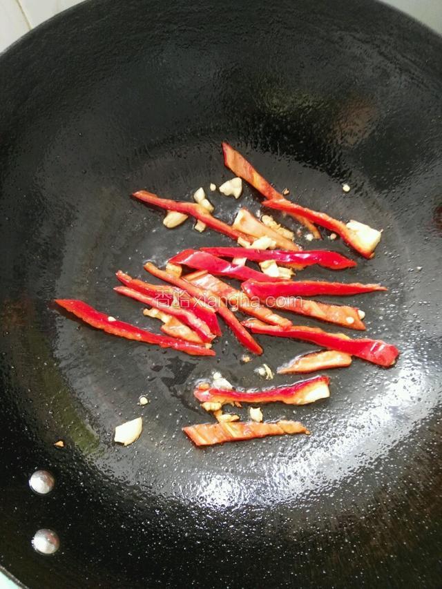 热锅倒入油，再放蒜沫及红辣椒翻炒几下。