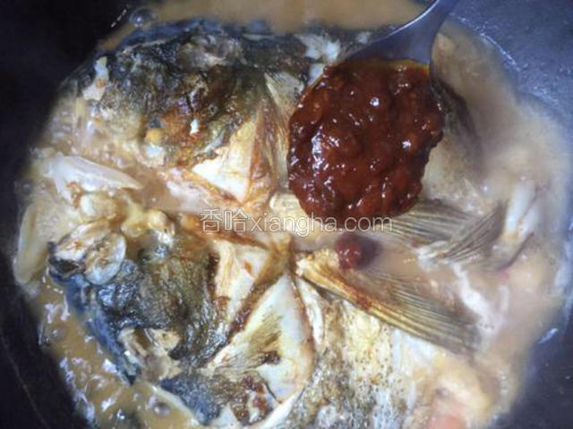 加入一大勺黄豆酱和适量的生抽，调色调味。中火煮一会儿，中途用勺子将汤汁浇在鱼头上面，至汤汁基本收干即可