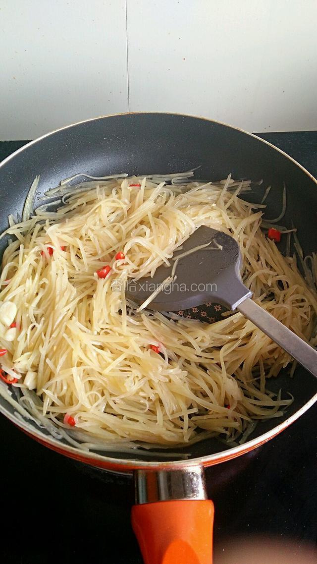 倒入沥干水的土豆丝，大火不停翻炒，快熟时调入适量盐、鸡精和陈醋，翻炒了均匀后关火。