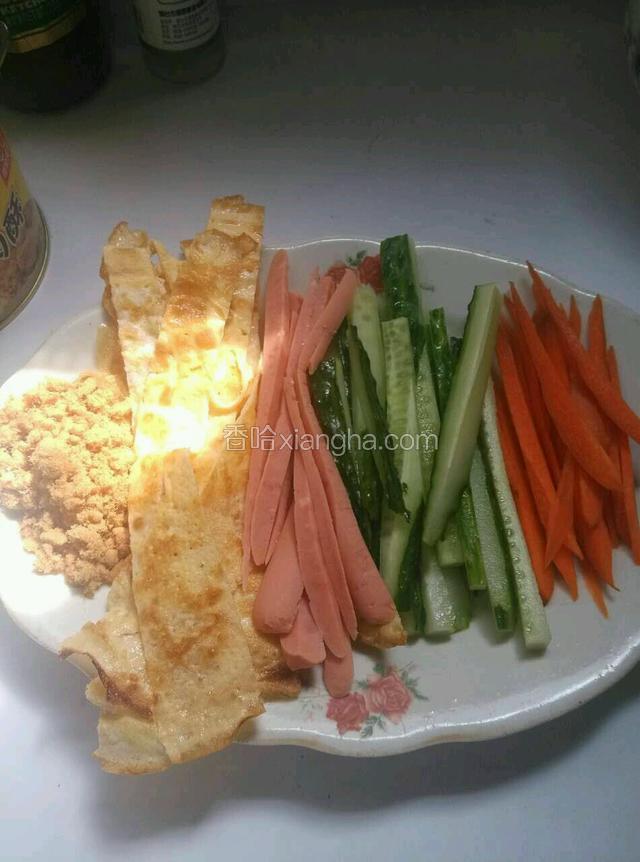 将胡萝卜，黄瓜，蛋皮，火腿肠个切成丝，并准备好肉松。（肉松可加可不加）