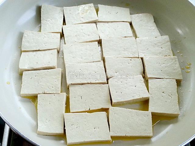 平底锅放少量油，将豆腐码入，中小火慢慢煎