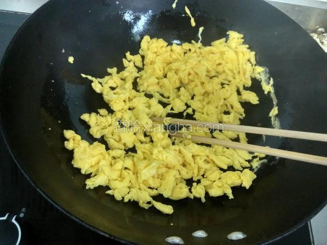热油把鸡蛋边炒边用筷子打散。