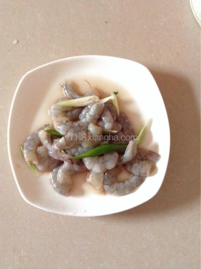 将虾摘取头部，剥去外衣，剔除虾肠，放料酒、葱和盐腌制十分钟。
