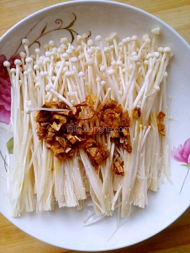锅中放入适量油，油热后，加入蒜末，爆出蒜香后。淋在金针菇上，如图。