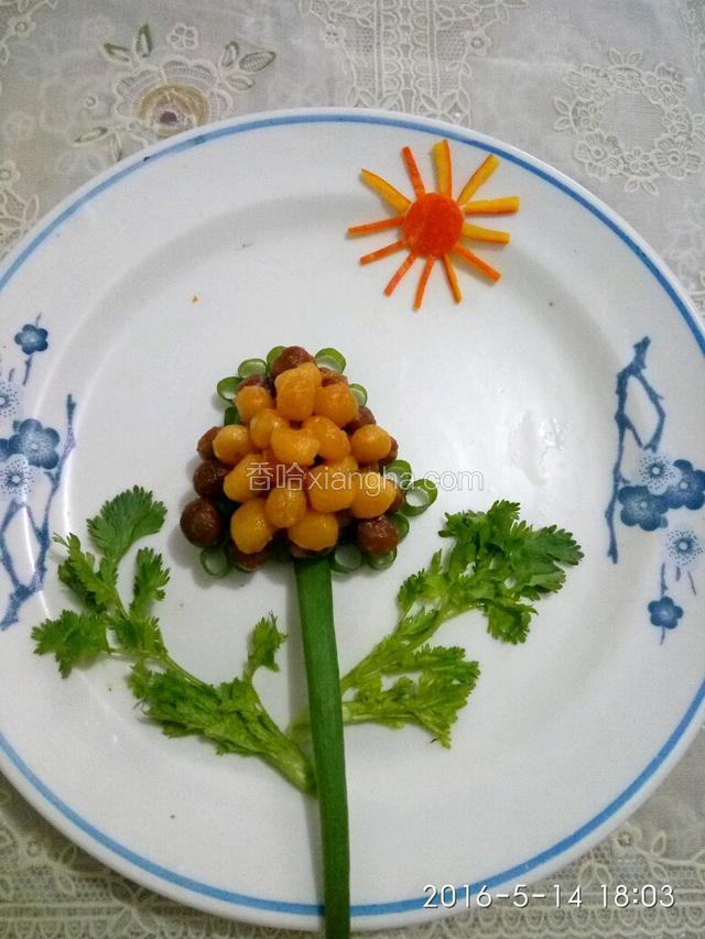 把炒好的小圆球摆放在小葱上，找根葱叶做树干，找二个香菜芯做枝叶，南瓜皮剪成的太阳。