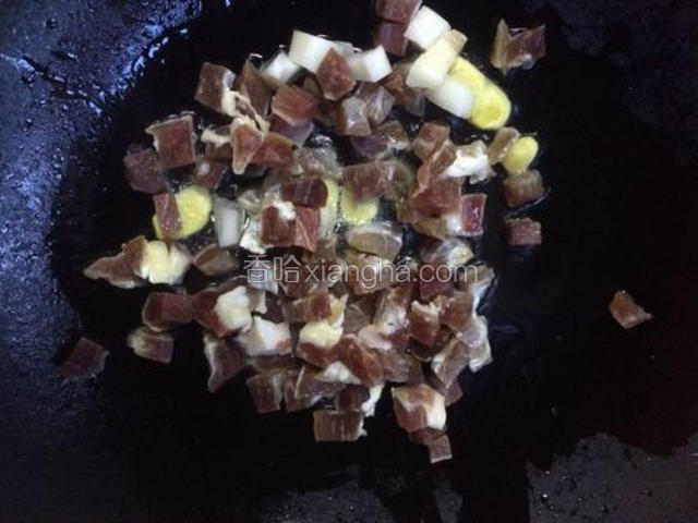 将腊肉丁倒入锅中继续炒至断生