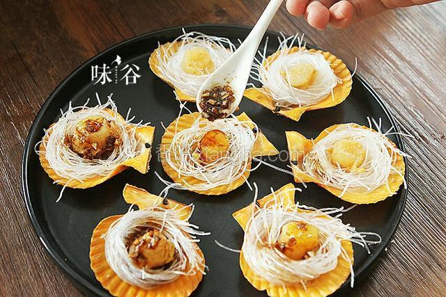 每个扇贝上淋上一点刚才做好的蒜蓉酱汁。
