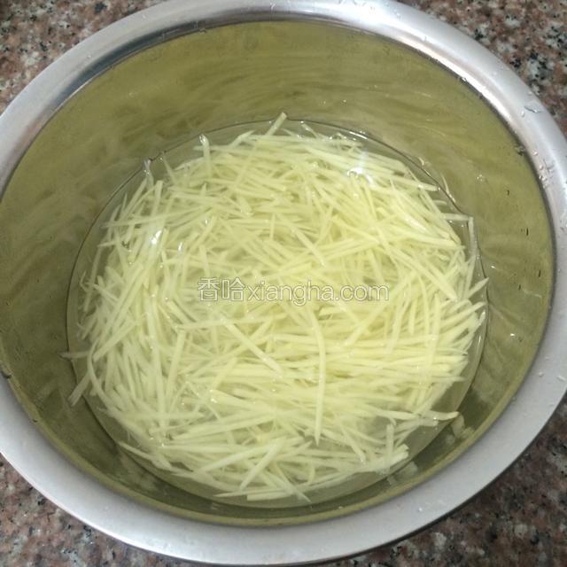 土豆去皮，刨成细丝，放入冷水中浸出淀粉，浸泡片刻，捞出沥干水分备用。