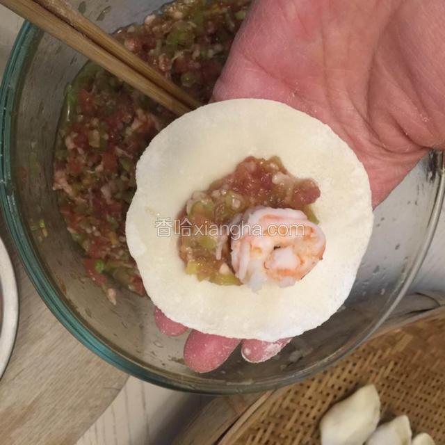 1.用擀面杖擀成饺子皮。
2.先放猪肉再放虾仁，用饺子皮包好。
