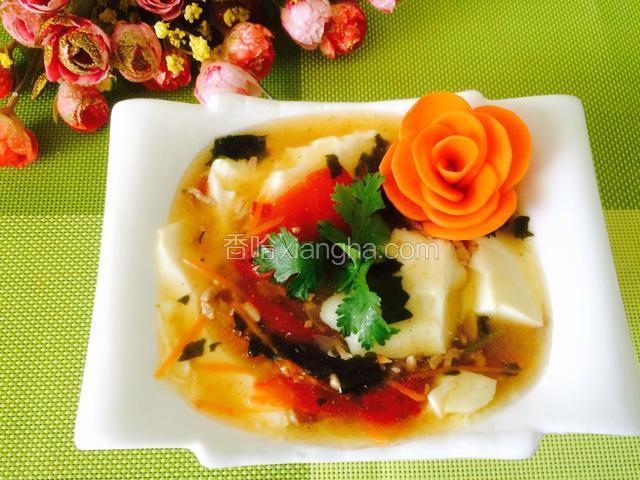 豆腐花、装入碗中，浇上汤汁、一碗热气腾腾、嫩嫩滑滑豆香四溢的豆腐花做好了、在配上一朵胡萝卜花，即漂亮又好吃。
