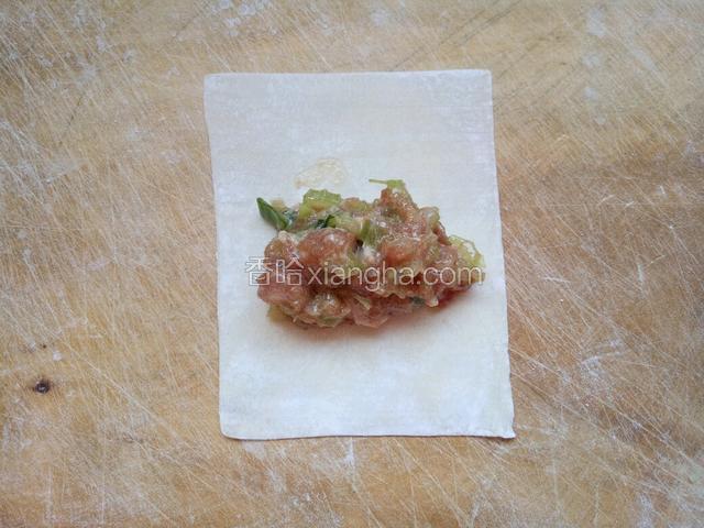 取一块馄饨皮，中间放上馅料