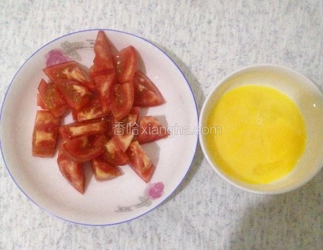 西红柿两个洗净后切成小丁，鸡蛋两颗打入碗中搅拌成蛋液
