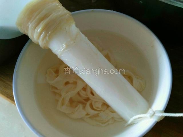 把肠衣顺一头套在漏斗嘴上，下面用棉线系好