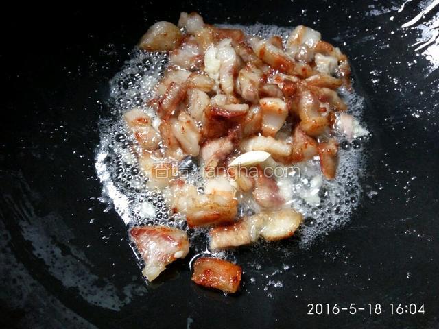 五花肉放锅里煎至金黄，加入蒜瓣，煸出香味。