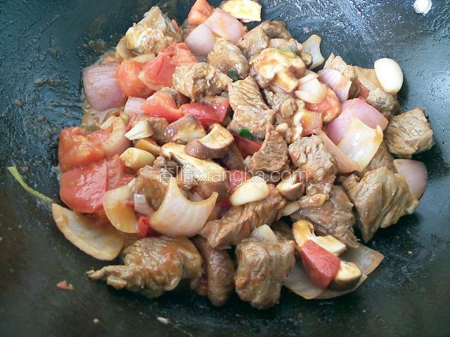 现在下入蔬菜，先放入洋葱翻炒出香味，再下西红柿翻炒，西红柿炒出汁以后，下香菇继续翻炒一会儿