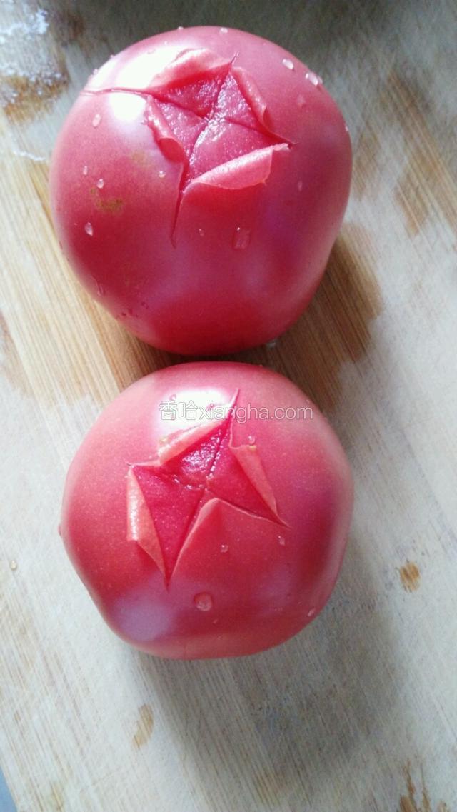 西红柿洗净，在顶部表面轻轻切十字，划破表皮即可。用开水把西红柿烫一下。