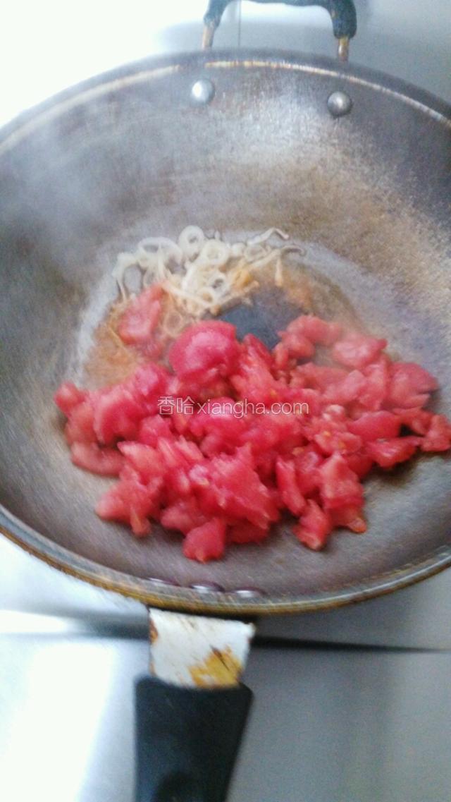 锅中放油烧至五成热，下入葱丝翻炒，再倒入西红柿继续翻炒