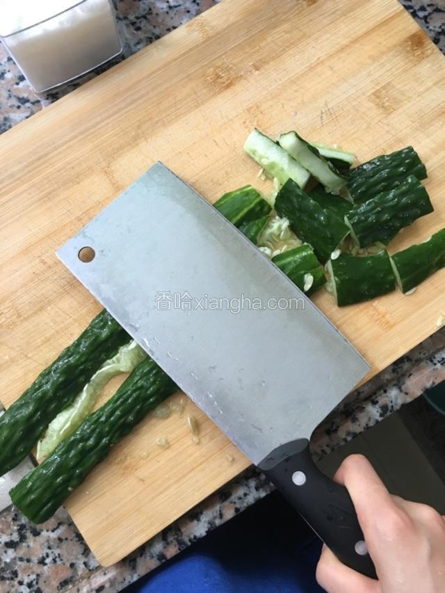 备好的青瓜对半切，把刀放平拍打青瓜，尽量拍碎点，好入味