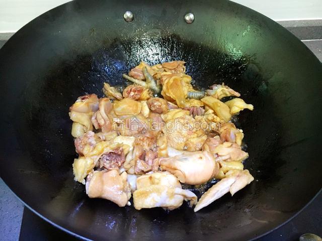 然后加入腌制好的鸡块下锅煎炒至上糖色。