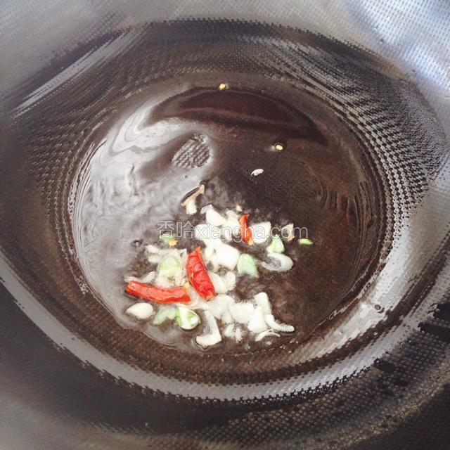 锅烧热后倒油，油烧热冒少许烟时倒入干红辣椒和葱花爆香