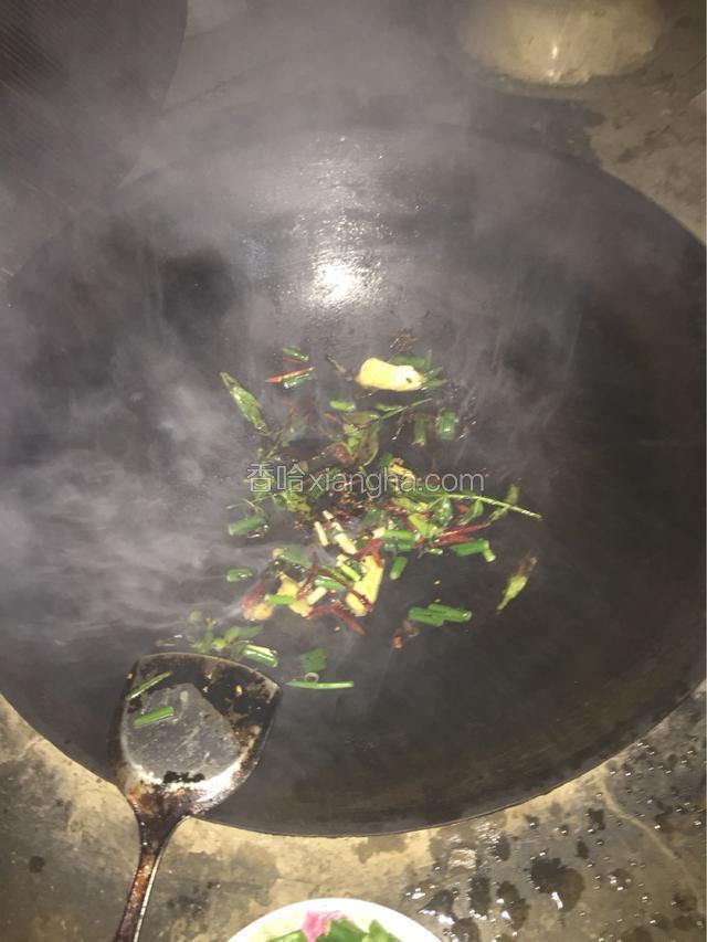 用地锅放油，把葱、姜辣椒、花椒叶、八角、茴香放锅里煸炒出香味。