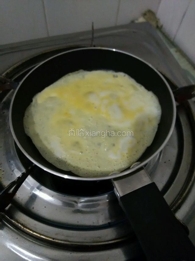 取1勺蛋液倒入煎锅，转动煎锅让蛋液均匀铺在锅底，蛋液完全凝固了翻面煎一下