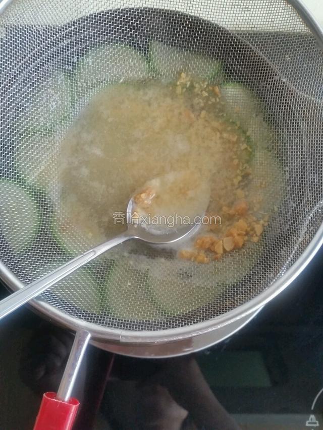 放入角瓜和蟹味菇，把滤网的1/3放汤水中，把大酱过滤放入锅内。