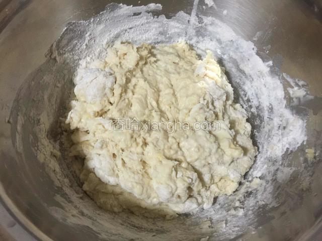 将沏好酵母粉的温水慢慢倒入面粉中，用筷子或手搅拌成絮状面团。