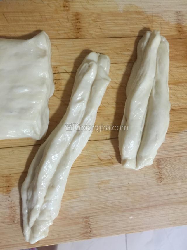 从左至右，切成大小适中的段状面团，每二段面团摞在一起，用一根筷子从中间压一道痕迹。