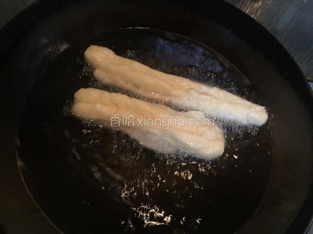 用长一些的筷子不时将正在炸制的油条翻面，使其两面能够均匀受热。