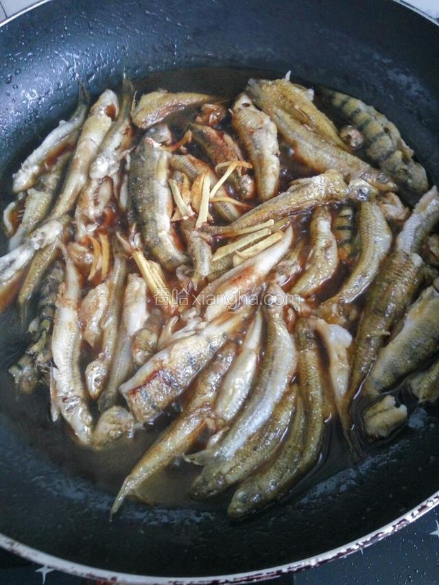 定型后淋些料酒，放入姜丝、老抽、白糖、盐、蒜粒加水盖上盖子煮3～5分钟