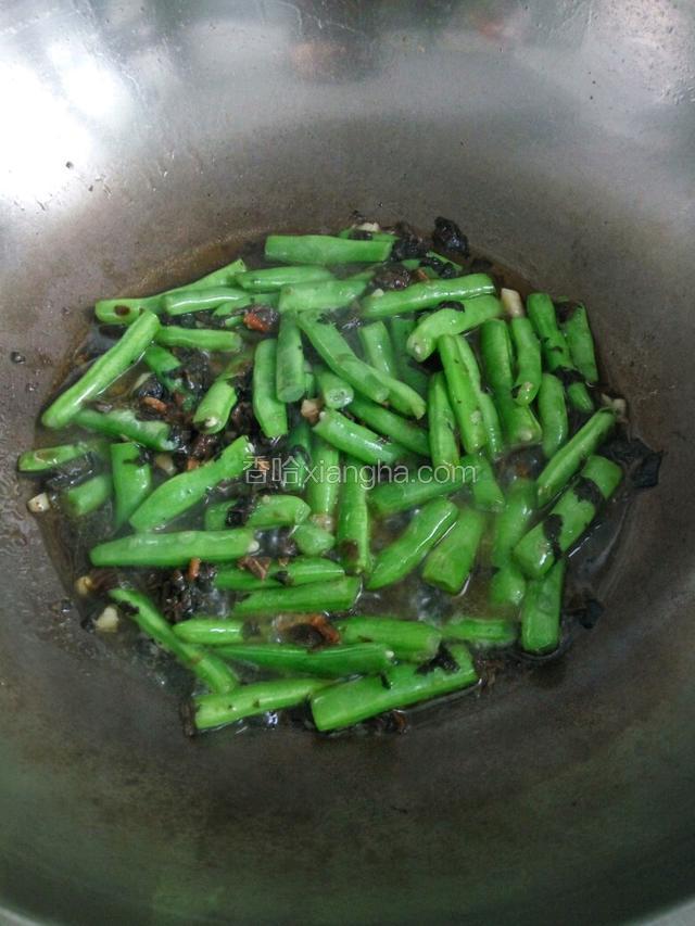 热锅凉油下入肥肉爆出油，下入蒜粒爆香，在下豆角煸炒片刻，在下入梅干菜翻炒均匀，放盐入适量的水稍煮2～3分钟