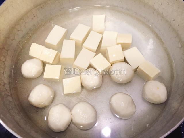 汤锅加入清水，豆腐切成小块和鱼丸同放入。