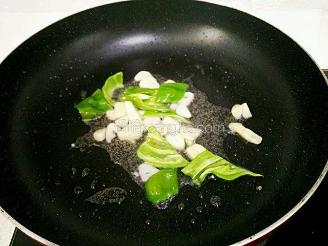 锅里留油，加入蒜片、青椒块，小火炒出香味。