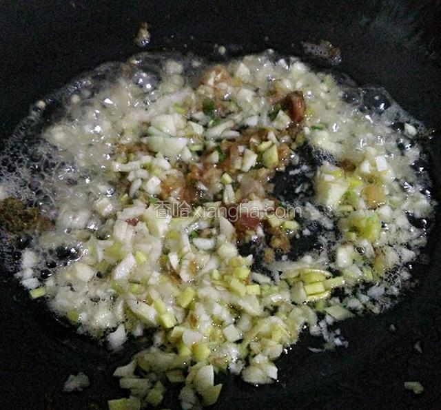 锅中热油，倒入大蒜生姜末和肉末炒香。