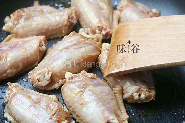 热锅放油，放姜片，鸡翅入内煎。
