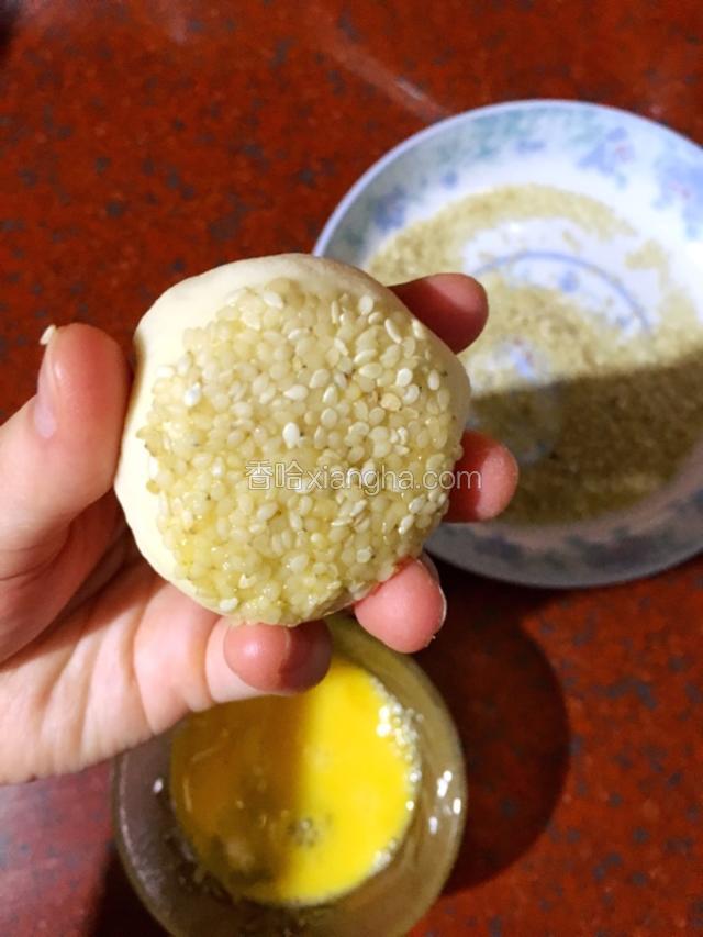 包子底部蘸蛋液后再蘸上芝麻