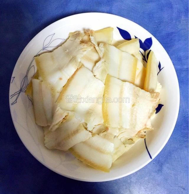 
将肥瘦相连的带皮猪肉刮洗干净，放入汤锅内，煮10分钟，至八成熟时捞出晾凉，切成5 厘米长、4 厘米宽、0.2 厘米厚的片
