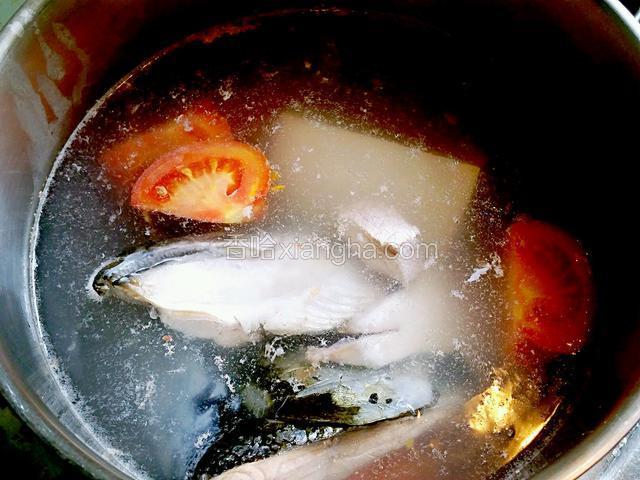 鍋裡下適量水煮沸後下三文魚頭，蕃茄，豆腐，瘦肉，薑片